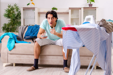 Young man husband ironing at home 