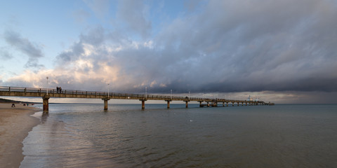 Fototapeta premium Sea bridge at the Baltic Sea against a dramatic sky with clouds 