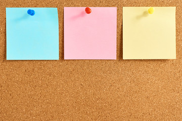 Cork board with a pinned colored blank notes