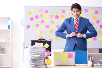 Young male handsome employee in conflicting priorities concept 