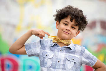 Proud young boy pointing to his bow tie
