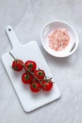 cherry tomatoes and himalayan salt on marble background