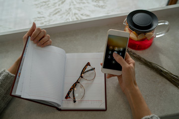 Selective focus on cellphone in hands. Close up view of woman internet user checks notification on...