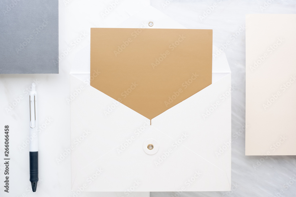 Poster Top view of  blank golden card in white envelop on two layer step of marble table top.Mock up template for display of design.modern business items