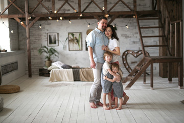 Fototapeta na wymiar Beautiful family with two sons in studio apartment