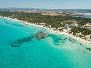 Fototapeta premium Amazing drone aerial landscape of the charming beach Es Trencs and the boats with a turquoise sea. It has earned the reputation of Caribbean beach of Mallorca. Spain