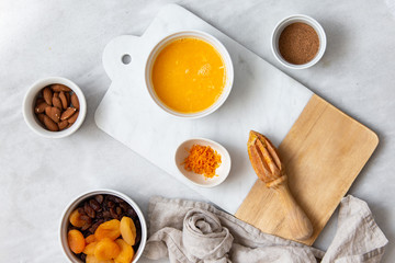 Fresh Orange Juice and Peel, raisins, dried apricots, almonds on marble backround with copy space