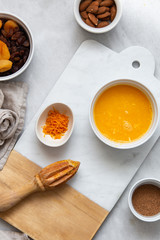 Fresh Orange Juice and Peel, raisins, dried apricots, almonds on marble backround with copy space