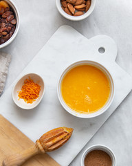 Fresh Orange Juice and Peel, raisins, dried apricots, almonds on marble backround with copy space