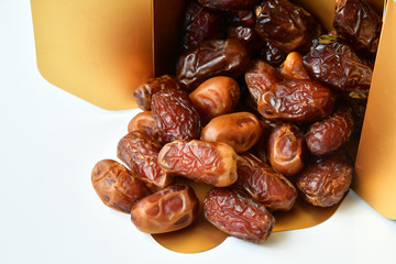 Dried dates in a box on white background