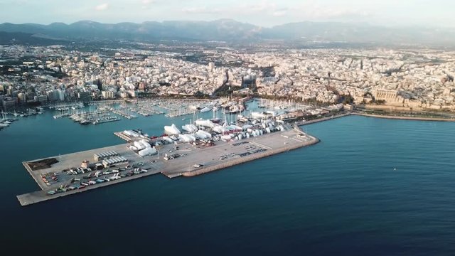 Picturesque aerial view of the coastal city harbour with many boats, mountains and cloudy sky. Stock. Beautiful sea port and the blue sea.