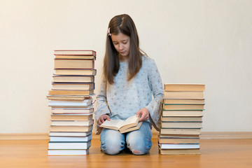 Girl reading a book sitting on the floor in an apartment. Cute girl reading book at home. education...