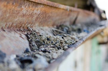 Old rusty rain gutter with pebbles