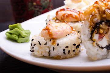 Sushi rolls on a white platter with black sesame.