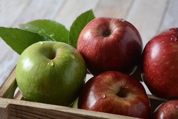 Fresh red and green apples in wooden box in rustic style. Healthy food 