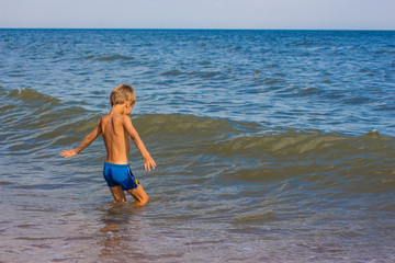 Fototapeta premium The boy is swimming in the sea without hiding joy.