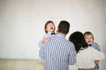 Screaming naughty boys in hands of their parents