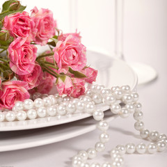 pastel colored tableware set: plate, vintage silverware on napkin and delicate pink roses 