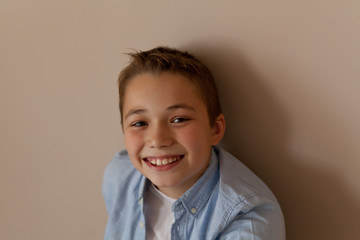 Portrait of a boy of 10 years old on a beige background