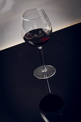 Red wine on a wineglass over a dark solid black background