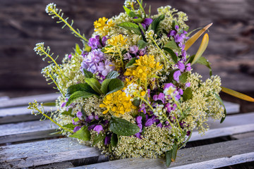 Bright bouquet of a variety of fresh wild flowers on a wooden background