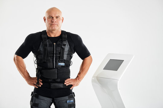 awesome muscular man testing EMS device. isolated white background. copy space. man keeping fit. fitness concept