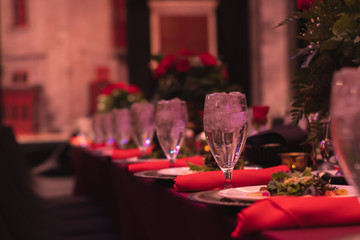 Fancy salad dinner on red banquet tables during an event.
