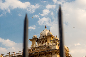 Albert hall in jaipur shot through an out of focus iron fence on a cloudy sky