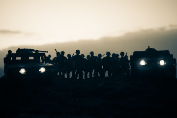 Fototapeta na wymiar Military patrol car on sunset background. Army war concept. Silhouette of armored vehicle with gun in action. Decorated. Selective focus