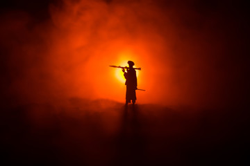 Naklejka na ściany i meble Military soldier silhouette with bazooka. War Concept. Military silhouettes fighting scene on war fog sky background, Soldier Silhouette aiming to the target at night