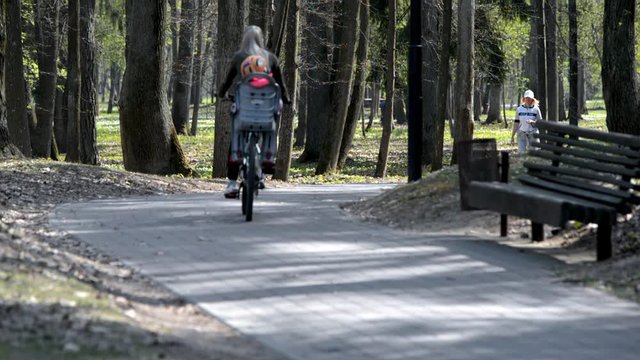 A girl with a child riding a bike in the Park 