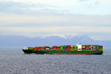 Big container ship, fully loaded with containers, sailing near Japanese island Hokkaido. 