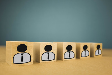 wooden cubes standing in a row, meaning wage workers standing in one line, abstraction on a blue background.