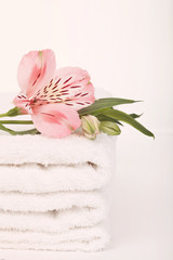 Stack of bath towels with flower on white background