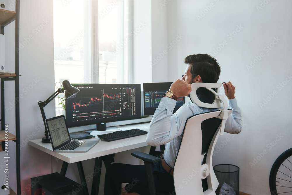 Poster i need to relax. sleepy young businessman or trader with hands raised feeling tired after working al