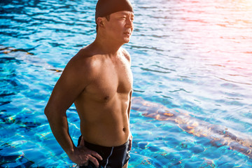 Young athletic man swimming in the swimming pool