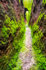 Narrow exterior labyrinths of LaLibela in Ethiopia carved out of the bedrock, covered by a green moss