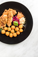 Fried chicken with potato balls and salad, restaurant serving portion