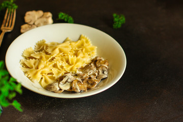 pasta farfalle with julienne mushrooms (fresh dish). food background. top