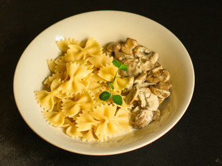 pasta farfalle with julienne mushrooms (fresh dish). food background. top