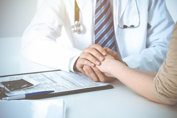 Hand of doctor  reassuring her female patient. Concepts of medical ethics and trust in medicine