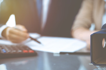 Binders with papers waiting to be processed with businessman or bookkeeper back in blur. Accounting...