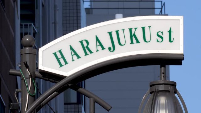 Static shot of a Harajuku sign, on a street, in Tokyo, Japan