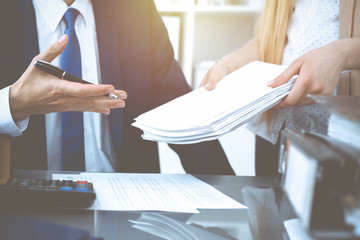 Fototapeta premium Bookkeeper or financial inspector hands making report, calculating or checking balance. Internal Revenue Service inspector man checking financial document. Business, tax and audit concepts