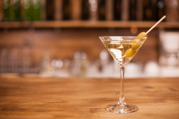 A glass of martini on the bar counter of a elegant restaurant