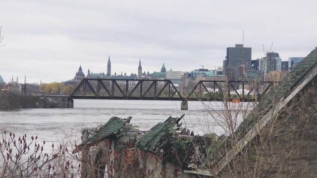 View of Parliament hill over a destroyed home on Ottawa River during 2019 flood.