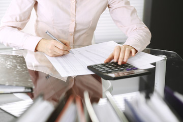 Bookkeeper woman or financial inspector  making report, calculating or checking balance, close-up.  Business, audit or tax concepts