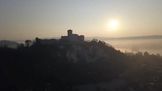Rocca di Angera castle in the morning with the morning fog still clinging to the town below.