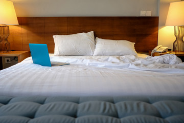 Working in bed , laptop on white bed in hotel room. Bussines trip