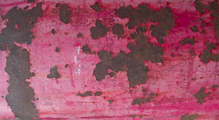 Pink vintage metal background with cracked paint. Flat lay, top view.
